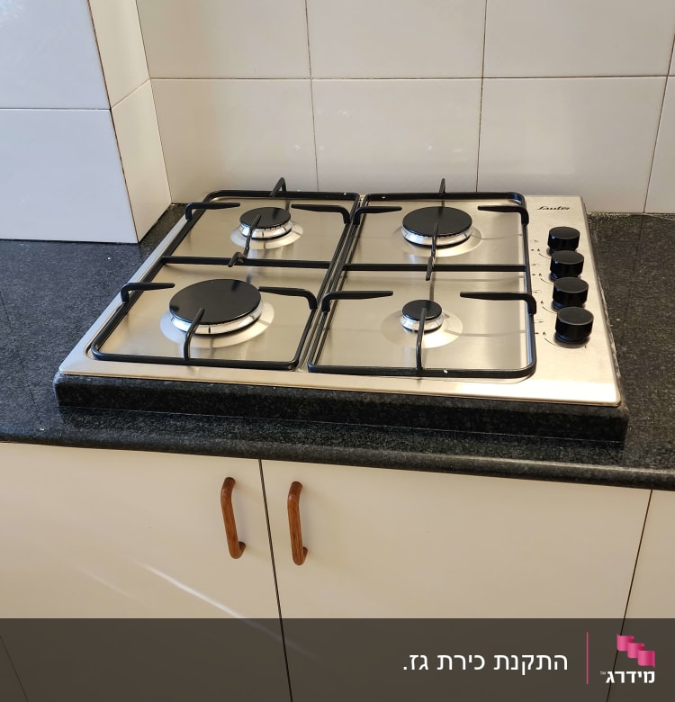 כיריים גז עם ארבעה מבערים וכפתורי שליטה